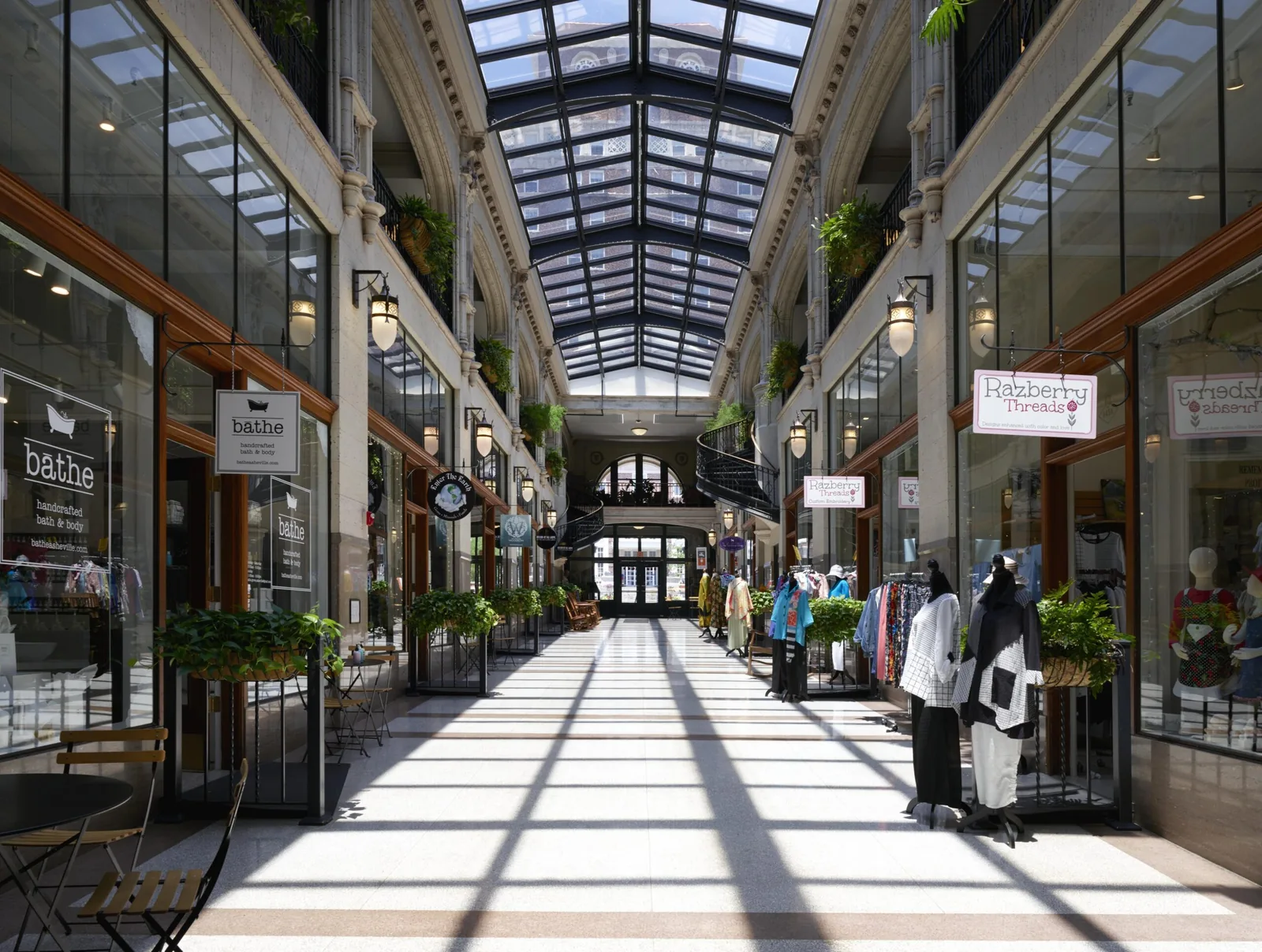 Daylight through the glazed roof of the Grove Arcade interior arcade lined with independent shopfronts