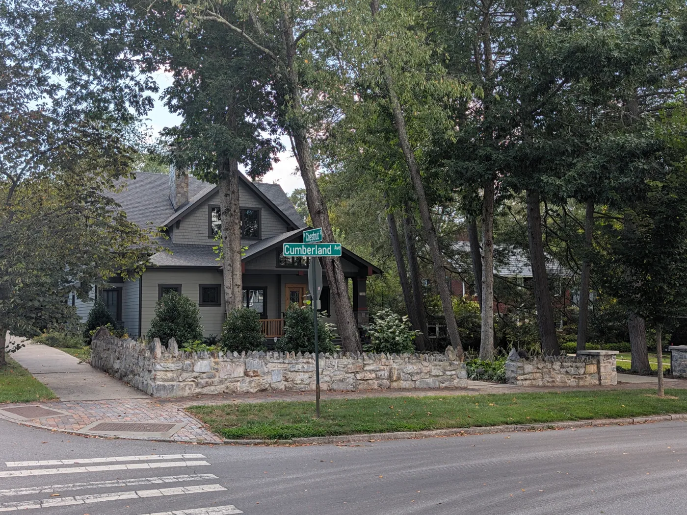 A residential corner on Cumberland Avenue in Montford, with sidewalk, crosswalk and stone wall